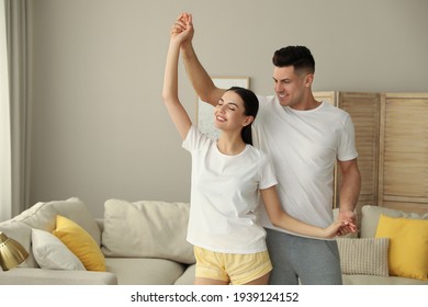 Happy Couple In Pyjamas Dancing At Home