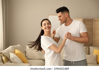 Happy Couple In Pyjamas Dancing At Home