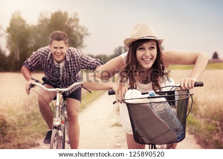 Happy couple racing on bikes