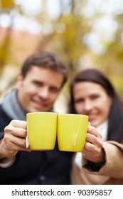 Happy Couple Raising Glasses With Hot Tea In Autumn