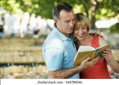 Happy Couple Reading A Guidebook Outdoors