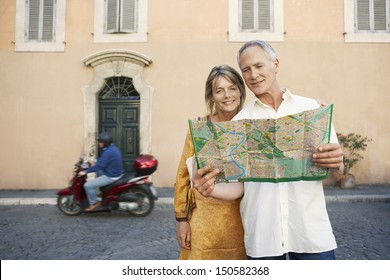 Happy couple reading map on street in Rome; Italy