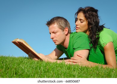 Happy Couple Reading Outdoors In Summer