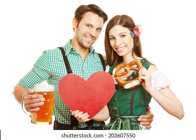 Happy couple with red heart and beer at Oktoberfest in Bavaria