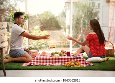 Happy Couple With Refreshing Drinks Imitating Picnic At Home