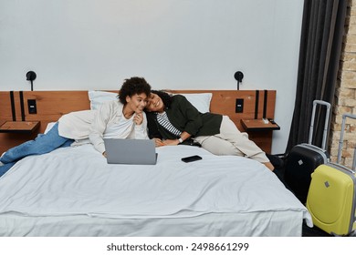 A happy couple relaxes and connects while enjoying their cozy hotel room adventure. - Powered by Shutterstock