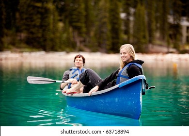 A Happy Couple Relaxing In A Canoe On A Glacial Lake