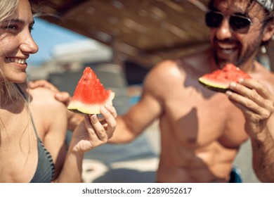 happy couple relaxing and eating watermelon together on vacation at  beach - Powered by Shutterstock