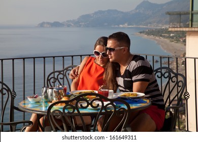 Happy Couple Relaxing On A Hotel Balcony