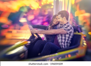 Happy Couple Ride Bumper Car On A Fun Fair Amusement