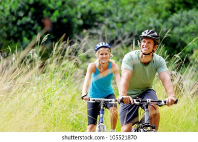 Happy couple riding bicycles outside, healthy lifestyle fun concept. mountain bike fitness outdoor exercise together