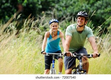 Happy couple riding bicycles outside  healthy lifestyle fun concept