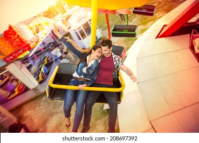 Happy couple riding on ferris wheel at amusement park