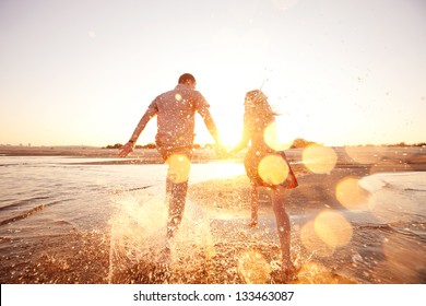 Happy Couple Running On The Beach