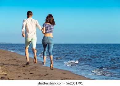 Happy Couple Running On Beach Stock Photo (Edit Now) 556802236