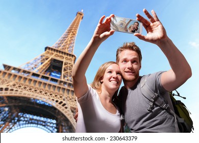 happy couple selfie by smart phone in Paris with eiffel tower, caucasian