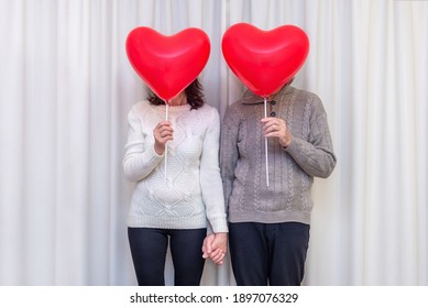 Happy Couple Seniors Celebrate Valentines Day. Faceless Couple With No Face Behind Heart Balloon. Romantic Relationships, Love And Dating In Retirement. Lifestyle Of Elderly People. Mature Pensioners