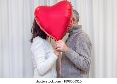 Happy Couple Seniors Celebrate Valentines Day. Faceless Couple With No Face Behind Heart Balloon. Romantic Relationships, Love And Dating In Retirement. Lifestyle Of Elderly People. Mature Pensioners