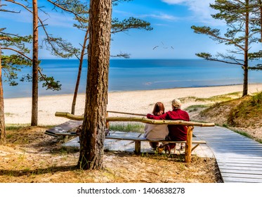 Happy couple of seniors are resting and looking at a distance near a sandy beach of the Baltic Sea - Powered by Shutterstock