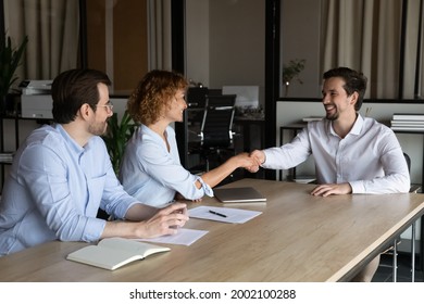 Happy couple shaking smiling manager hand at meeting in office, family closing successful insurance or investment deal, purchasing real estate, realtor broker congratulating satisfied customer - Shutterstock ID 2002100288