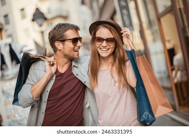 Happy couple shopping and laughing on city street - Powered by Shutterstock