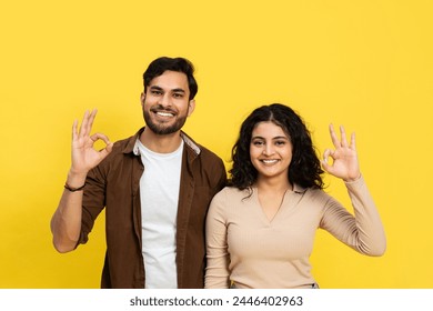 Happy Couple Showing Okay Sign Against Yellow Background - Positive Gesture, Relationship, and Satisfaction Concept