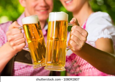 Happy Couple Sitting In Beer Garden In Summer And Enjoy A Glass Of Beer And The Sun