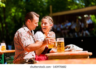 Happy Couple Sitting In Beer Garden And Enjoy The Beer And The Sun