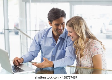 Schönes Paar mit Laptop im Café sitzen