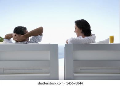 Happy couple sitting on armchairs enjoying vacation in resort - Shutterstock ID 145678844