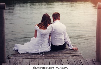 Happy couple sitting on a pier