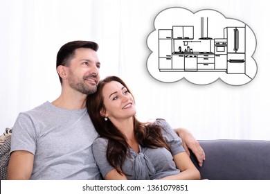 Happy Couple Sitting On Sofa Dreaming About New Kitchen