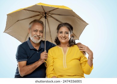 A HAPPY COUPLE SITTING TOGETHER UNDER AN UMBRELLA AND LOOKING AT CAMERA
 - Powered by Shutterstock