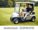 A happy couple smiles at each other while riding in a golf cart through a beautiful landscape filled with greenery and sunshine, perfectly capturing themes of lifestyle and leisure