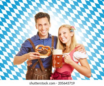 Happy couple smiling with beer at Oktoberfest in Bavaria
