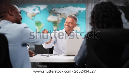 Happy Couple Smiling While Visiting Travel Agency Office To Choose Vacation Package. A Diverse Group Of People Handshake