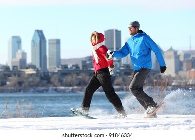 Happy couple snowshoeing running in montreal with cityscape skyline and river st. Lawrence in background. Healthy lifestyle photo from Montreal, Quebec, Canada. - Powered by Shutterstock