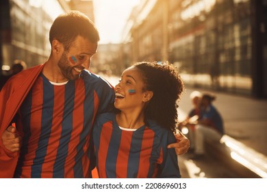 Happy Couple Of Soccer Fans Talking On The Street While Going On A Match Together.