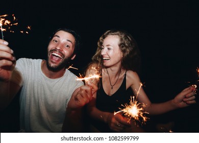 Happy couple with sparklers in the night - Powered by Shutterstock