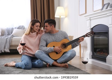 Happy couple spending time together near fireplace at home - Powered by Shutterstock