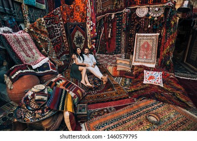 Happy couple in the store. Couple in love in Turkey. Man and woman in the Eastern country. Gift shop. A couple in love travels. Persian shop. Tourists in store. Oriental carpet. Istanbul. Cappadocia