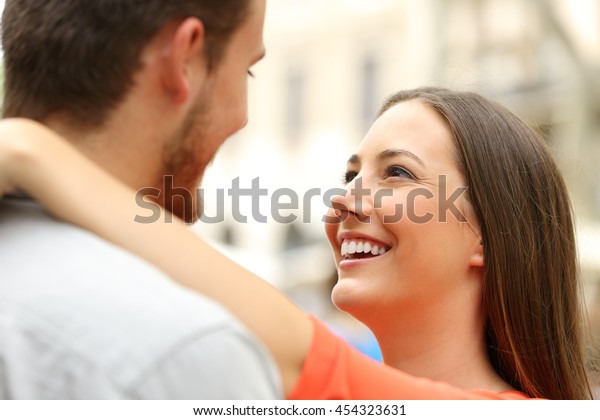 Happy couple in the street looking each other\
falling in love