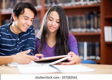 Happy couple of students at the library