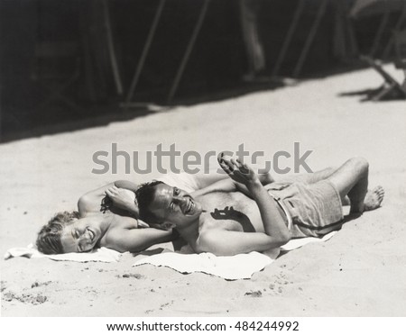 Happy couple sunbathing on beach