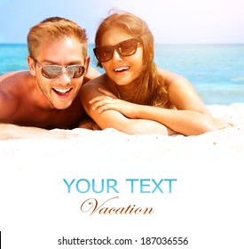 Happy Couple In Sunglasses Having Fun On The Beach. Summer Vacation. Laughing Family Enjoying Nature Over Sea Background. Attractive Man And Woman At The Beach. Sun Tan