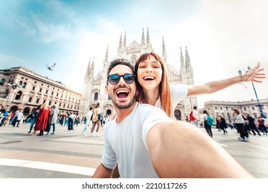 Happy couple taking selfie in front of Duomo cathedral in Milan, Lombardia - Two tourists having fun on romantic summer vacation in Italy - Holidays and traveling lifestyle concept - Shutterstock ID 2210117265