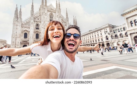 Happy couple taking selfie in front of Duomo cathedral in Milan, Lombardia - Two tourists having fun on romantic summer vacation in Italy - Holidays and traveling lifestyle concept - Shutterstock ID 2260863393