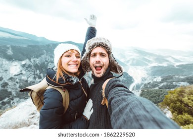 Happy couple taking a selfie hiking mountains - Successful hikers on the top of the peak smiling at camera  - Powered by Shutterstock