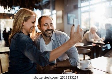 Happy couple taking selfie in a modern cafe - Powered by Shutterstock