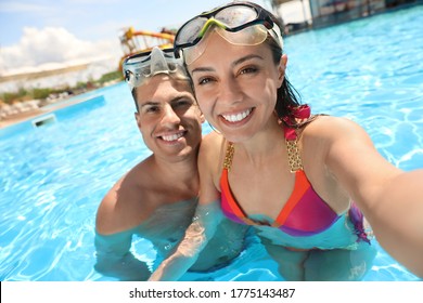 Happy couple taking selfie in swimming pool. Summer vacation - Powered by Shutterstock